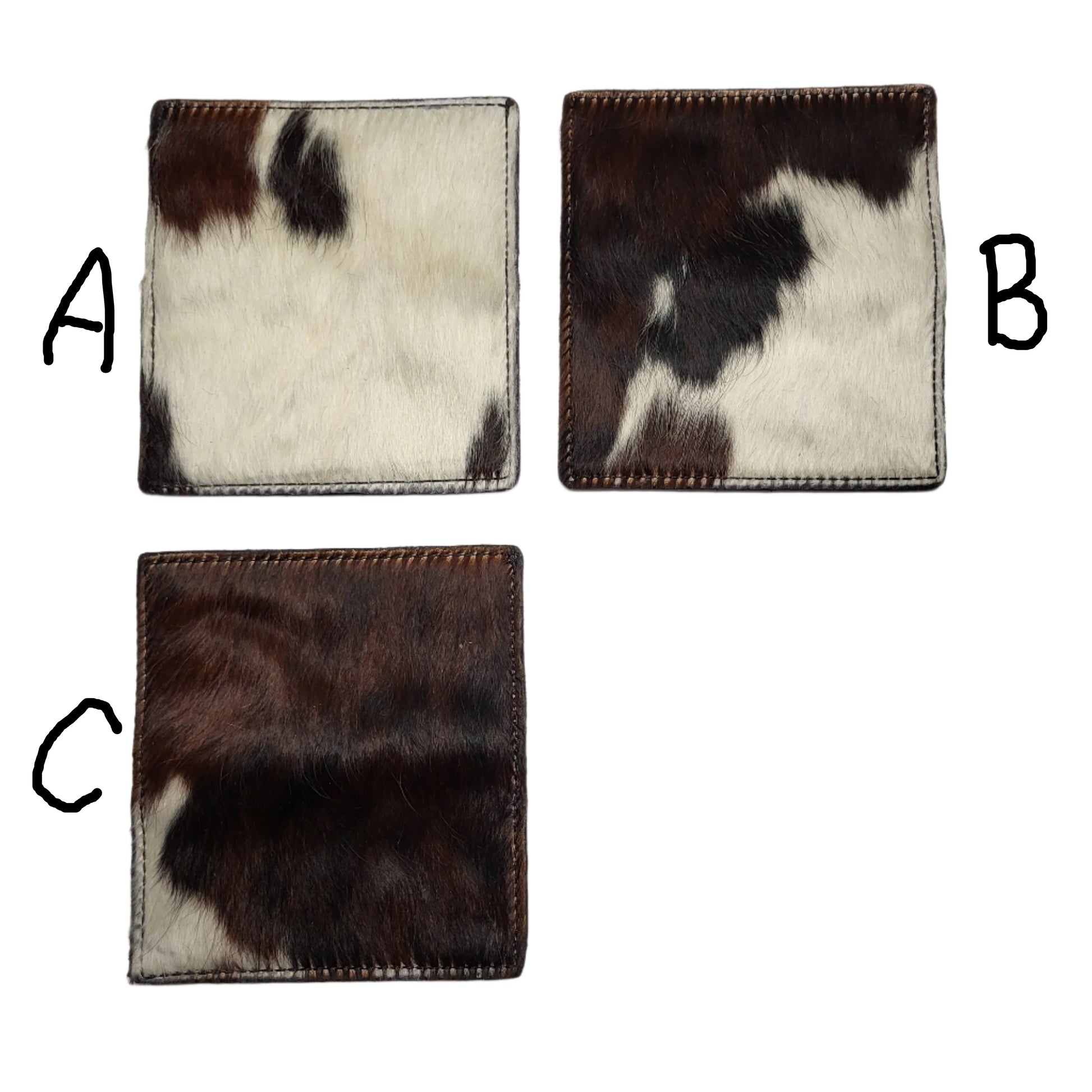 Three cowhide checkbook covers with brown, black, and white cowhide pattern on a white surface.